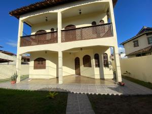 a large white house with a balcony on top at Casa para a temporada com 3 quartos a caminho do centro in Porto Seguro