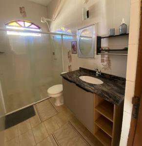 a bathroom with a sink and a toilet and a shower at Casa para a temporada com 3 quartos a caminho do centro in Porto Seguro +31 photos