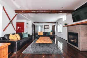 a living room with a couch and a fireplace at Hakuba Slopeside Chalet in Otari