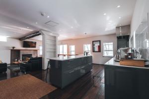 a large kitchen and living room with a counter top at Hakuba Slopeside Chalet in Otari