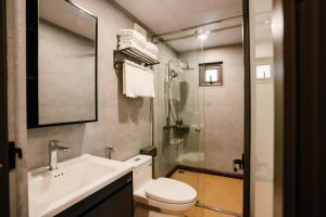 a bathroom with a toilet and a sink and a shower at Bai Tu Long Mountain Resort in Hà Cái +90 photos