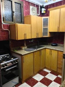 a kitchen with wooden cabinets and a stove at Kemet Pyramids Apartments in Cairo