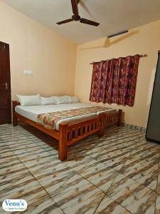 a bedroom with a bed and a ceiling fan at Venu's Homestay in Varkala