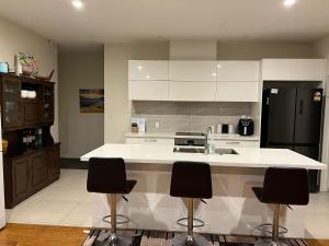 a kitchen with a white counter and black appliances at Rana Niwas in Rolleston