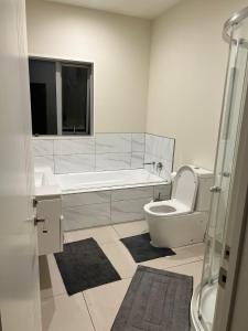 a bathroom with a toilet and a sink and a shower at Rana Niwas in Rolleston