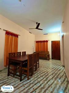 a dining room with a table and chairs and a couch at Venu's Homestay in Varkala