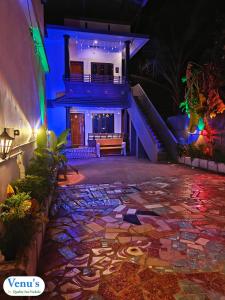 a house with a stone walkway in front of a building at Venu's Homestay in Varkala