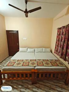 a bed in a room with a ceiling fan at Venu's Homestay in Varkala