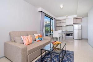 a living room with a couch and a table at Surin Condo Walk to Beach with Rooftop Pool - C416 in Ban Lum Fuang