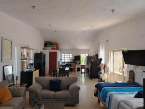 a living room with a bed and a couch at Rancho de Solis in Arteaga