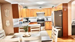 a kitchen with wooden cabinets and a table and a refrigerator at Belle-Rive - family friendly Guest House in Edmonton