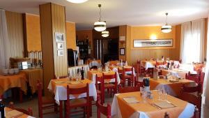 a restaurant with tables and chairs with yellow tablecloths at Hotel La Lanterna in Chiesa in Valmalenco