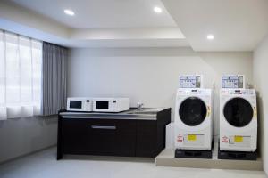 a laundry room with two washers and a sink at WAYPOINT TSUKIJI Tokyo in Tokyo