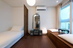 a bedroom with two beds and a mirror at Seoul Station ㅣThe interior of a hanok with a terrace in Seoul