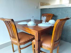 a wooden table with two chairs and a table with dishes on it at Japa Amerta Villa in Amed