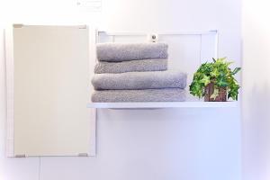 a stack of towels on a shelf next to a mirror at Clair US Tokyo-Disney & Tokyo Sightseeing Base in Tokyo
