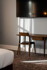 a bedroom with a desk and a chair next to a bed at Kincraig Hotel in Naracoorte +30 photos
