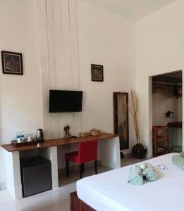 a room with a desk and a tv on the wall at La Fontaine de Tara Boutique Hotel in Siem Reap