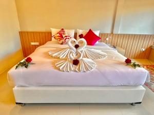 a bed with two swans made out of pillows at Transit Samui Resort in Koh Samui