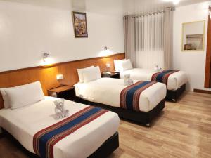 a hotel room with two beds with stuffed animals on them at Saphi Inn Cusco - Excelente ubicación in Cusco
