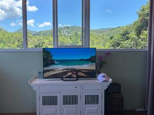 a tv sitting on a cabinet in front of a window at Spectacular Sunrise and Mountain Views in Mae Nam