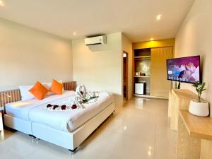 a bedroom with a large bed and a flat screen tv at Transit Samui Resort in Koh Samui
