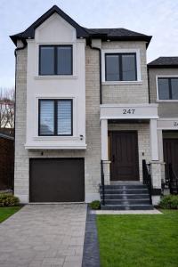 a white brick house with a garage at Luxury House with Open Living Space in Toronto