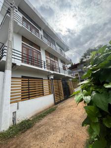 a white building with wooden doors and a balcony at Colombo - Kelaniya House in Kelaniya