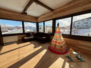 a living room with a large room with windows at KONAYUKI Apartment in Myoko