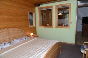 a bedroom with a bed and two windows at Apartment Dijak in Bohinj