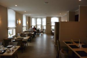 布隆貝爾格的住宿－德意誌之家酒店，一间设有桌椅的餐厅,有坐在桌子上的人