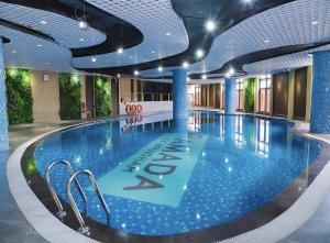 a large pool in a hotel with blue ceilings at Ha Long 2BR Apartment - Spacious & Modern - Near Center in Ha Long
