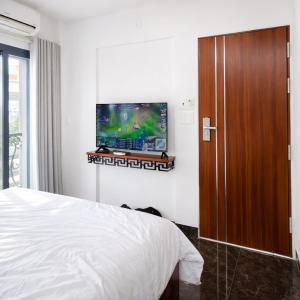 a bedroom with a bed and a flat screen tv at ICHI Home Kim Long in Hue