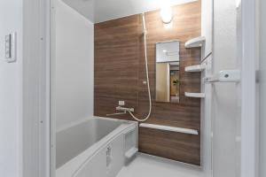 a bathroom with a bath tub and a sink at Crystal Jade Awaza2-4F in Wada