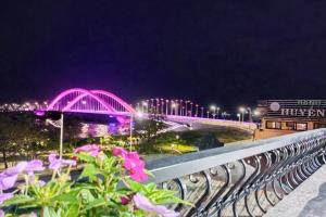 a view of a bridge at night with purple lights at ICHI Home Kim Long in Hue