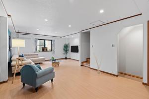 a living room with a blue chair and a couch at Crystal Jade Awaza2-4F in Wada