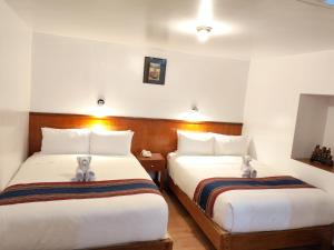 two beds in a hotel room with two stuffed animals on them at Saphi Inn Cusco - Excelente ubicación in Cusco
