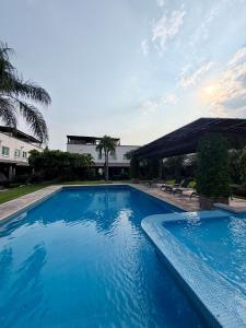 a large blue swimming pool next to a building at Casa con terraza frente alberca in Tezoyuca