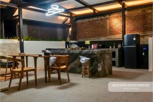 a restaurant with a table and chairs and a bar at Matappa Guest House in Pulau Sarang