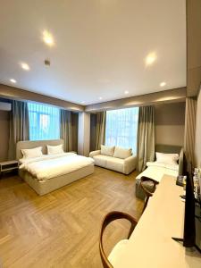 ein großes Schlafzimmer mit zwei Betten und einer Couch in der Unterkunft Hotel Elora in Almaty