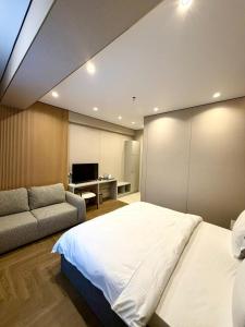 ein Schlafzimmer mit einem großen Bett und einer Couch in der Unterkunft Hotel Elora in Almaty