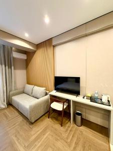 ein Wohnzimmer mit einer Couch und einem Schreibtisch in einem Zimmer in der Unterkunft Hotel Elora in Almaty