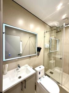 ein Badezimmer mit Waschbecken und Dusche mit Spiegel in der Unterkunft Hotel Elora in Almaty + 9 Fotos