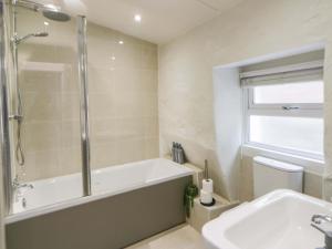 a bathroom with a tub and a toilet and a sink at Fern Cottage in Cardigan +42 photos