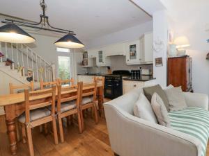 a kitchen and living room with a table and a couch at Rose Cottage in Cardigan