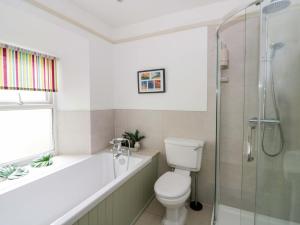 a bathroom with a toilet and a glass shower at Rose Cottage in Cardigan +44 photos