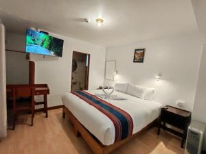 a bedroom with a bed and a desk and a tv at Saphi Inn Cusco - Excelente ubicación in Cusco +74 photos