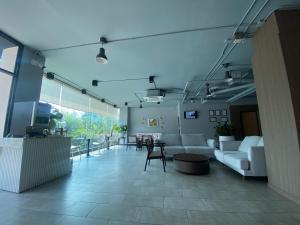 a living room with couches and a table and chairs at WE Valley Hotel in Chiang Mai