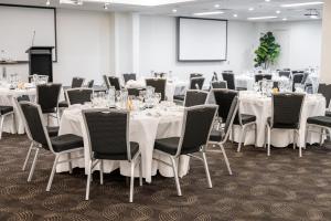 a conference room with white tables and chairs at voco Gold Coast by IHG in Gold Coast +103 photos
