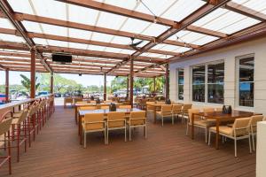 a restaurant with tables and chairs on a deck at Royal Mail Hotel in Tewantin